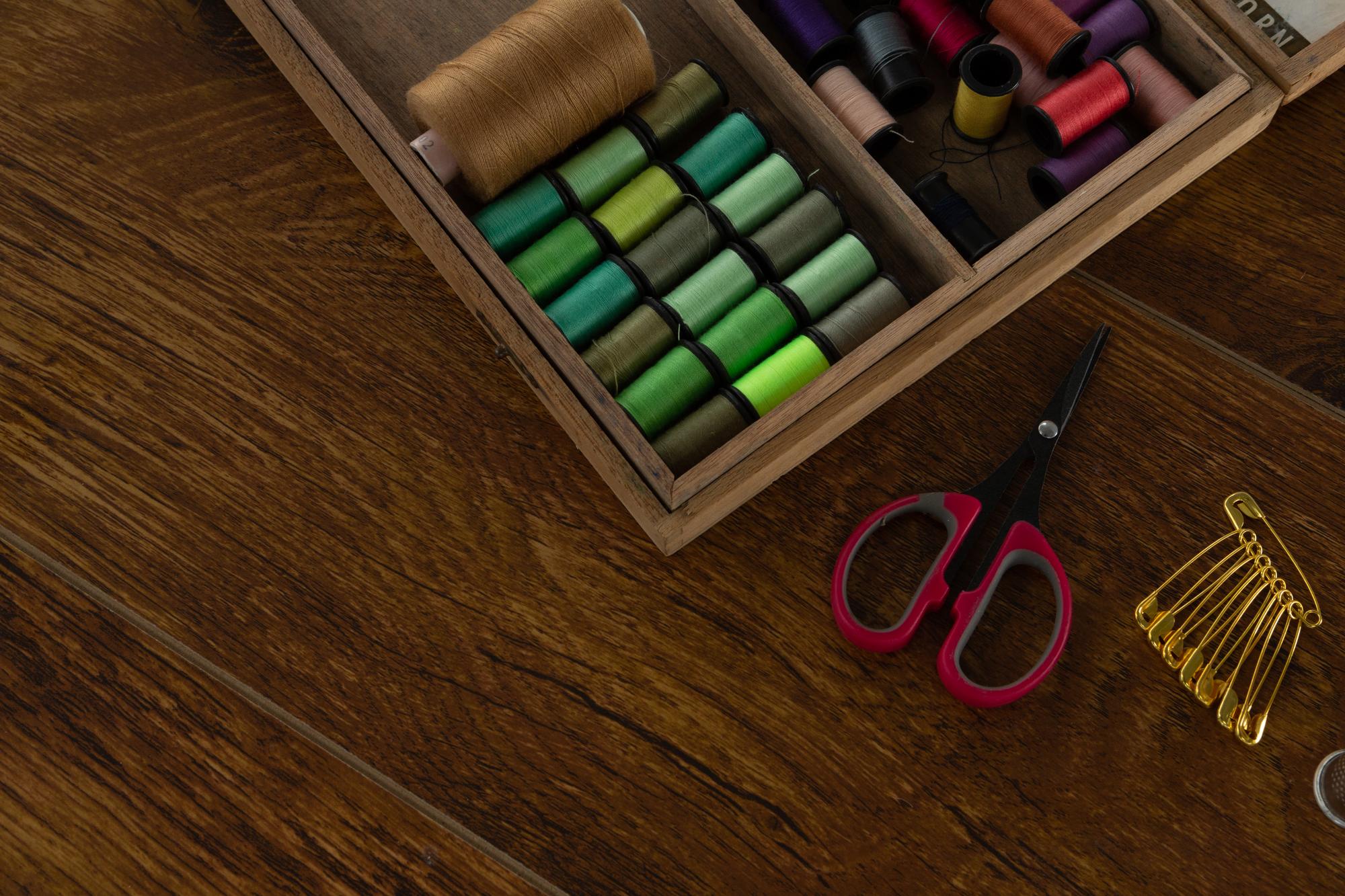 Stitched sampler and thread spools on wooden table